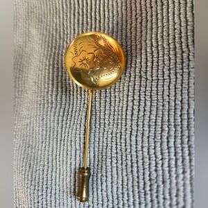 vintage gold-colored locket on a stick pin